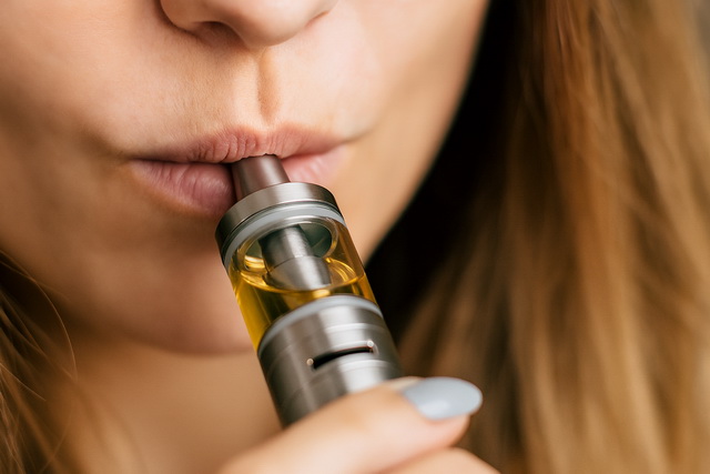 Frau beim Dampfen einer E-Zigarette – Vergleich Passivdampf und Passivrauch