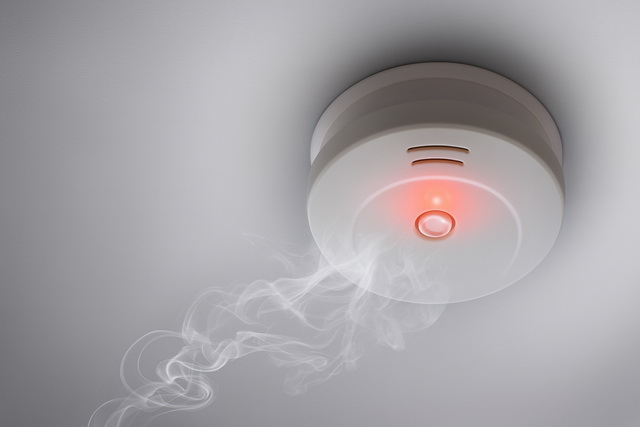 Rauchmelder an der Decke mit aufsteigendem E-Zigaretten-Dampf